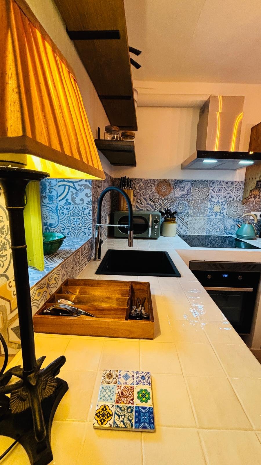 Kitchen with colourful tiles and warm lighting