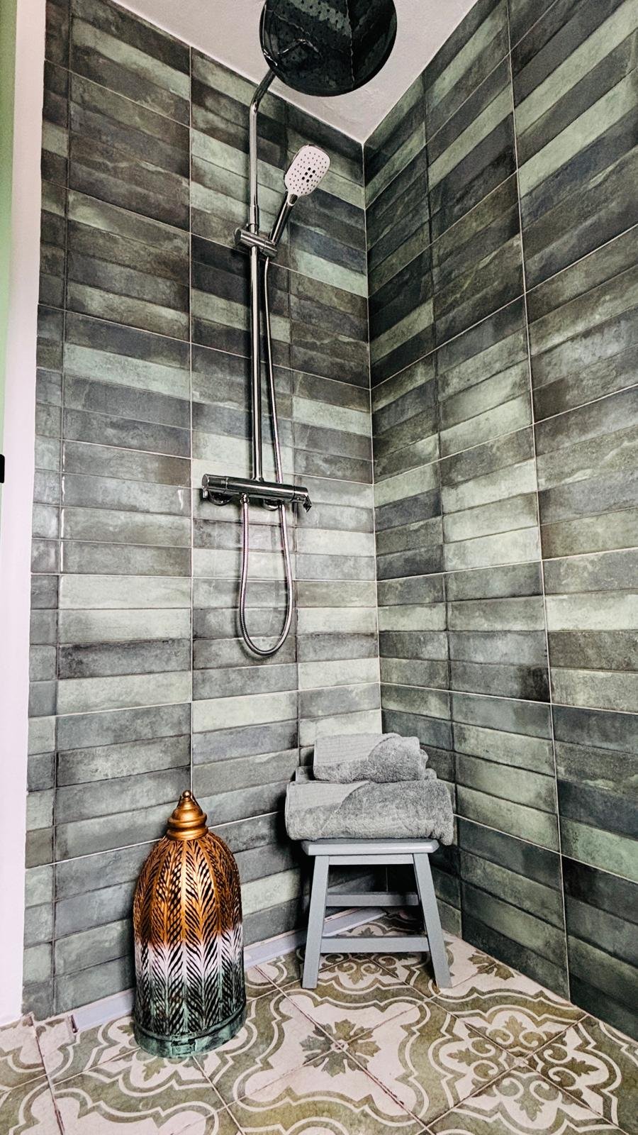 Walk-in shower with patterned grey tiles